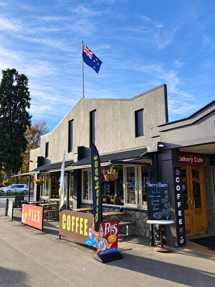 The Berry Barn frontage under the New Zealand flag, with coffee signs on the footpath
